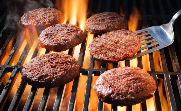 Beef hamburger patties sizzling on the barbecue